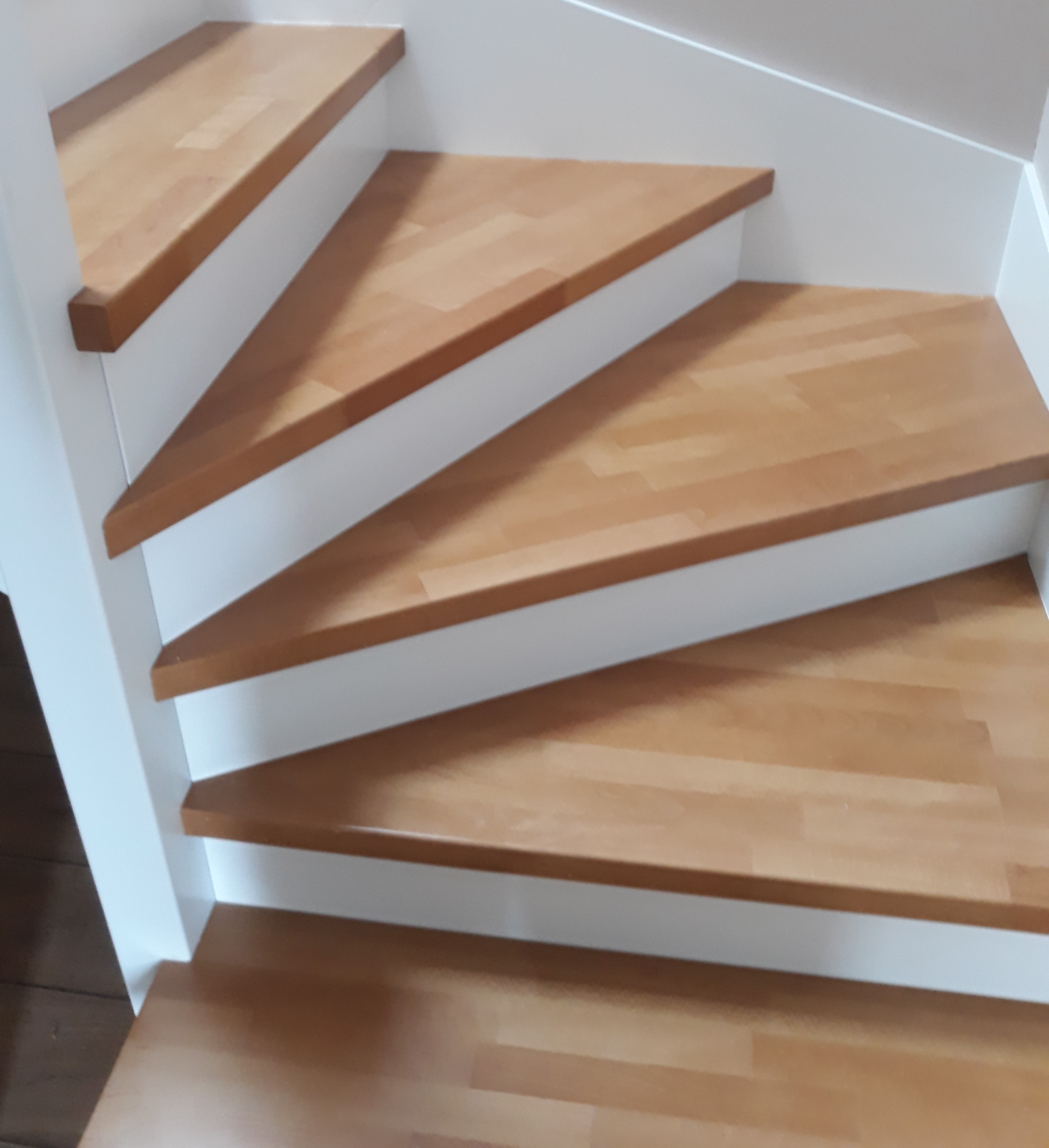 Schody z białą konstrukcją i naturalnymi stopniami